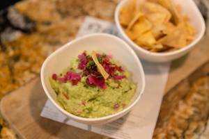 Guacamole - Dessert at Fit Kitchen Restaurant in Barcelona, Spain, served on a rustic wooden beam with tortilla chips