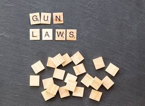 Gun laws on wooden tiles on a stone surface