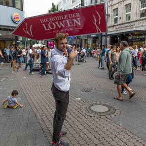 Gut gelaunter Sign Spinner in der Kölner Innenstadt