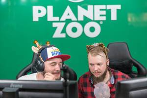 Guys with funny animalistic hair accessories playing Planet Zoo at Gamescom