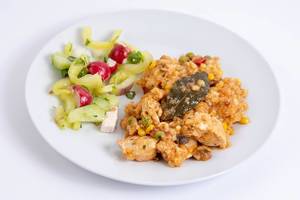 Hähnchen-Risotto mit Salat auf einem Mittagessens-Teller