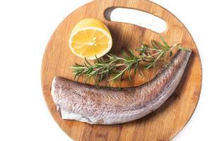 Hake Fish with Rosemary and Lemon on the wooden board