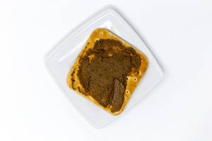 Hakuna Matata Eggplant Creme on a cracker on a square plate on white background