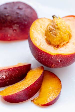 Half and sliced peach nectarine slices on white background (Flip 2019) (Flip 2019)