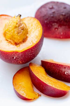 Half and sliced peach nectarine slices on white background