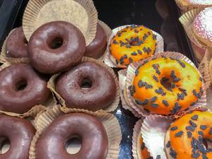 Halloween-Donuts in kürbis-orange mit kleinen Schokoladenfledermäusen