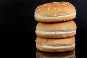 Hamburger Buns above black reflective background with copy space
