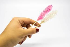 Hand holding pink and white rock candy