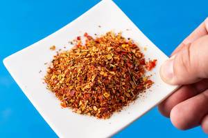 Hand holding plate with Red Grated Chilly Pepper (Flip 2019)