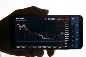 Hand holding smart phone with Ripple chart on screen