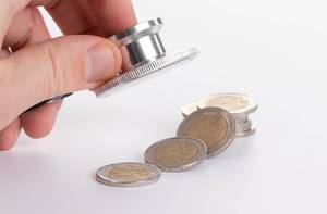 Hand holding stethoscope and 2 Euro coins on white background