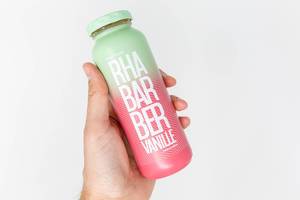 Hand holds a bottle of rhubarb-vanilla smoothie launched by true fruits as a spring 2020 special edition