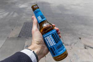 Hand holds Spanish non-alcohol Lager Beer "Free Damm" in Barcelona