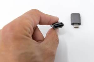 Hand holds the small USB adapter from Syntech, for USB-C and USB-OTG ports
