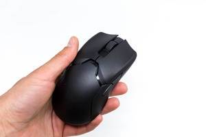 Hand holds the Viper Ultimate wireless gaming mouse by Razer in black, close-up on a white background