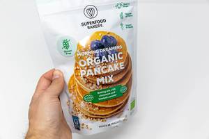 Hand holds vegan and organic Pancake baking mix with cinnamon and baobab powder by Superfood Bakery, is is gluten and dairy free