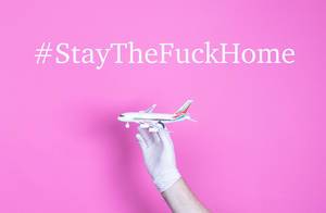 Hand in medical glove holding small airplane with #StayTheFuckHome text.jpg