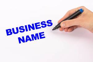 Hand mit blauem Edding-Marker schreibt den Text "Business Name"