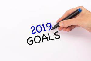 Hand mit Edding-Marker schreibt "2019 goals" (Ziele für 2019)-Text