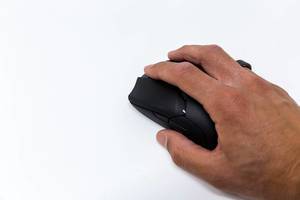 Hand of a gamer using the Razer Viper Ultimate wireless gaming mouse on a white background