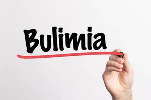 Hand schreibt Bulimia / Bulimie auf ein Whiteboard