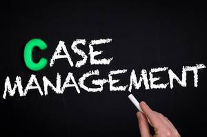 Hand schreibt das Wort "Case Management" - Fallmanagement - mit Kreide auf eine schwarze Tafel