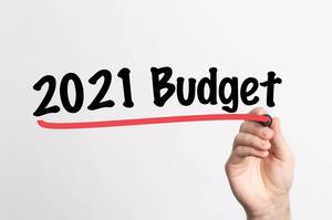 Hand schreibt "Budget für 2021" auf ein Whiteboard