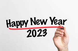 Hand schreibt  "Frohes neues Jahr 2023" auf ein Whiteboard