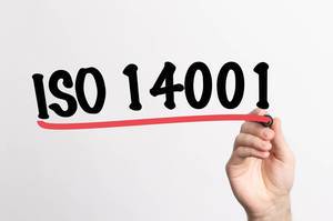 Hand schreibt "ISO 14001" auf ein Whiteboard