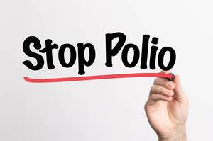 Hand schreibt "Polio stoppen" auf ein Whiteboard