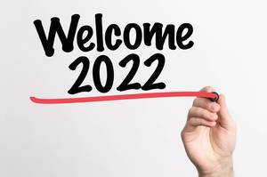 Hand schreibt "Willkommen 2022" auf ein Whiteboard