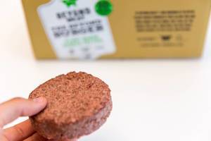 Hand shows Beyond Meat Patty - a healthy, plant-based alternative of burger meat