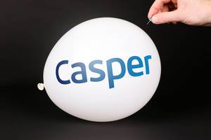Hand uses a needle to burst a balloon with Casper logo