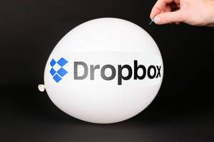 Hand uses a needle to burst a balloon with Dropbox logo
