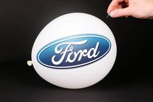 Hand uses a needle to burst a balloon with Ford logo