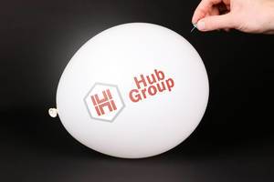 Hand uses a needle to burst a balloon with Hub Group logo