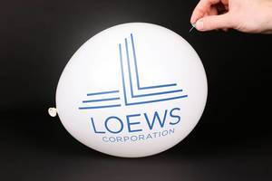 Hand uses a needle to burst a balloon with Loews logo