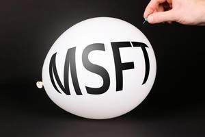 Hand uses a needle to burst a balloon with MSFT text