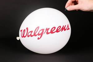 Hand uses a needle to burst a balloon with Walgreens logo