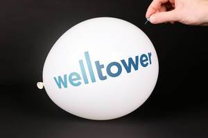 Hand uses a needle to burst a balloon with Welltower logo