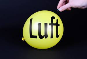 Hand uses a needle to burst a yellow balloon with Luft text