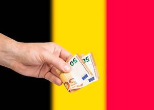 Hand with Euro banknotes over flag of Belgium