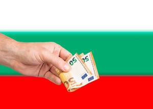Hand with Euro banknotes over flag of Bulgaria