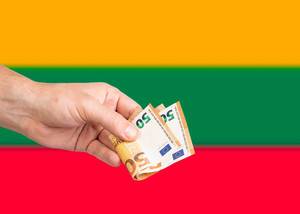 Hand with Euro banknotes over flag of Lithuania
