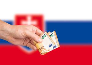 Hand with Euro banknotes over flag of Slovakia