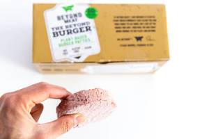Hand zeigt Beyond Meat Patty als eine gesunde veganische und glutenfreie Alternative zum Burger-Fleisch