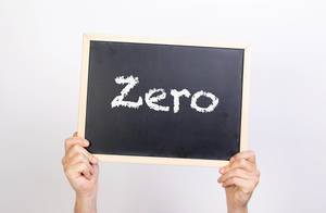 Hände halten eine Kreidetafel hoch, mit dem Wort "Zero" - Null