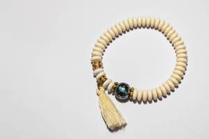Handgemachtes Armband aus weißen Steinen mit Goldeinsätzen und grüner Schmuckperle