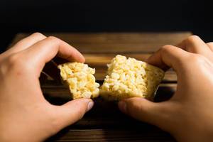 Hands breacking a rice krispies block