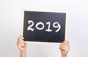 Hands holding blackboard with 2019 text